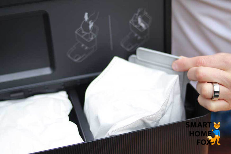 A dust bag is changed in the iRobot Roomba emptying station.